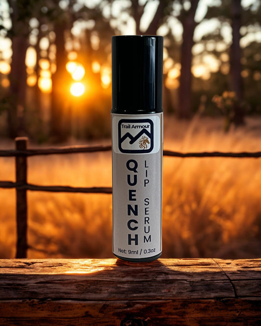 Trail Armour QUENCH lip serum roller on a timber fence rail at sunset
