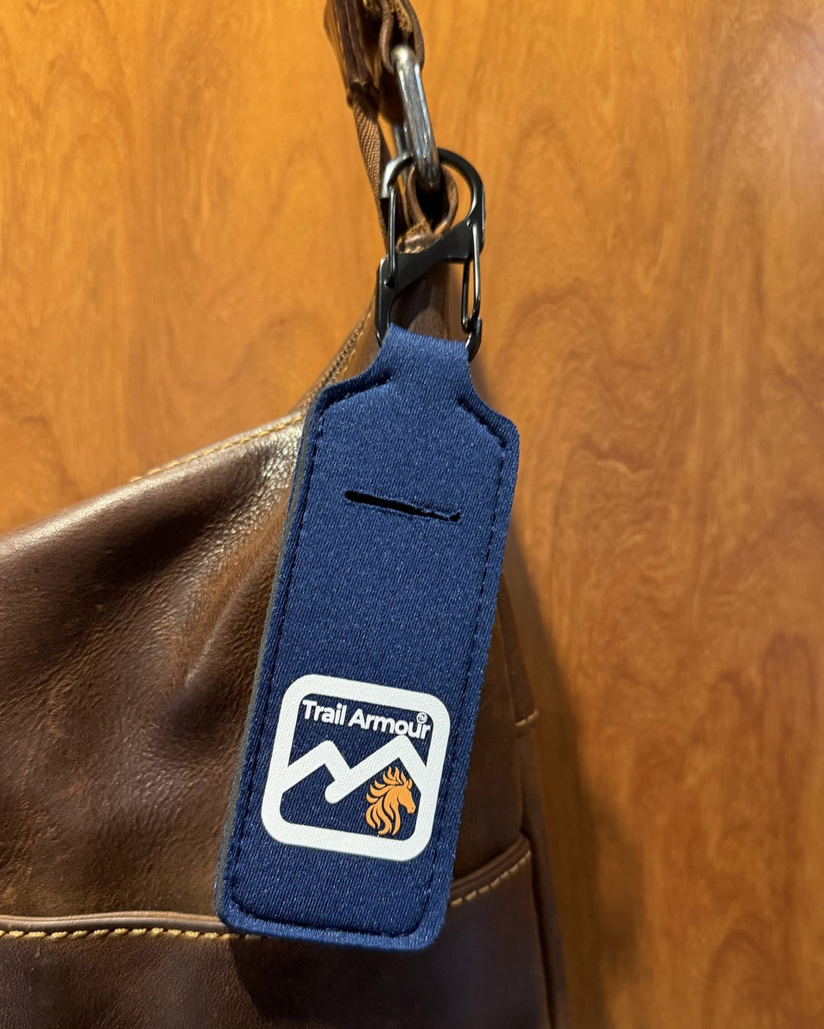 Navy neoprene Trail Armour lip balm holder showing the metal S clip and the slot in the front
